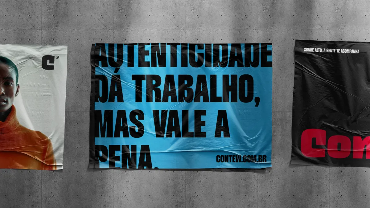 Cartazes colados em um muro de concreto, o maior em azul com a frase 'Autenticidade dá trabalho, mas vale a pena' e a assinatura contew.com.br