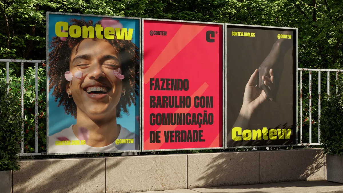 Três cartazes da Contew em uma grade ao ar livre, um deles vermelho com a frase 'Fazendo barulho com comunicação de verdade'